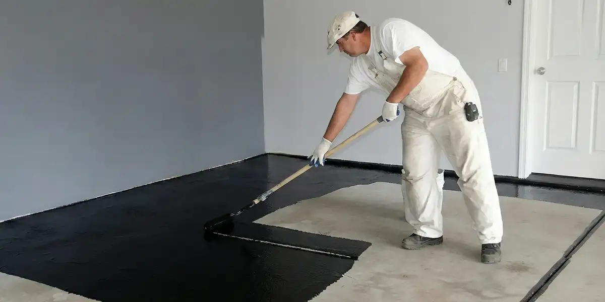 basement waterproofing professional applying waterproof coating to protect a basement floor in Madison, WI